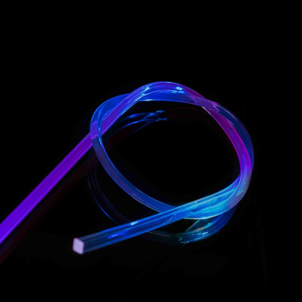 A coiled translucent light whip strand glowing blue and violet against a black background